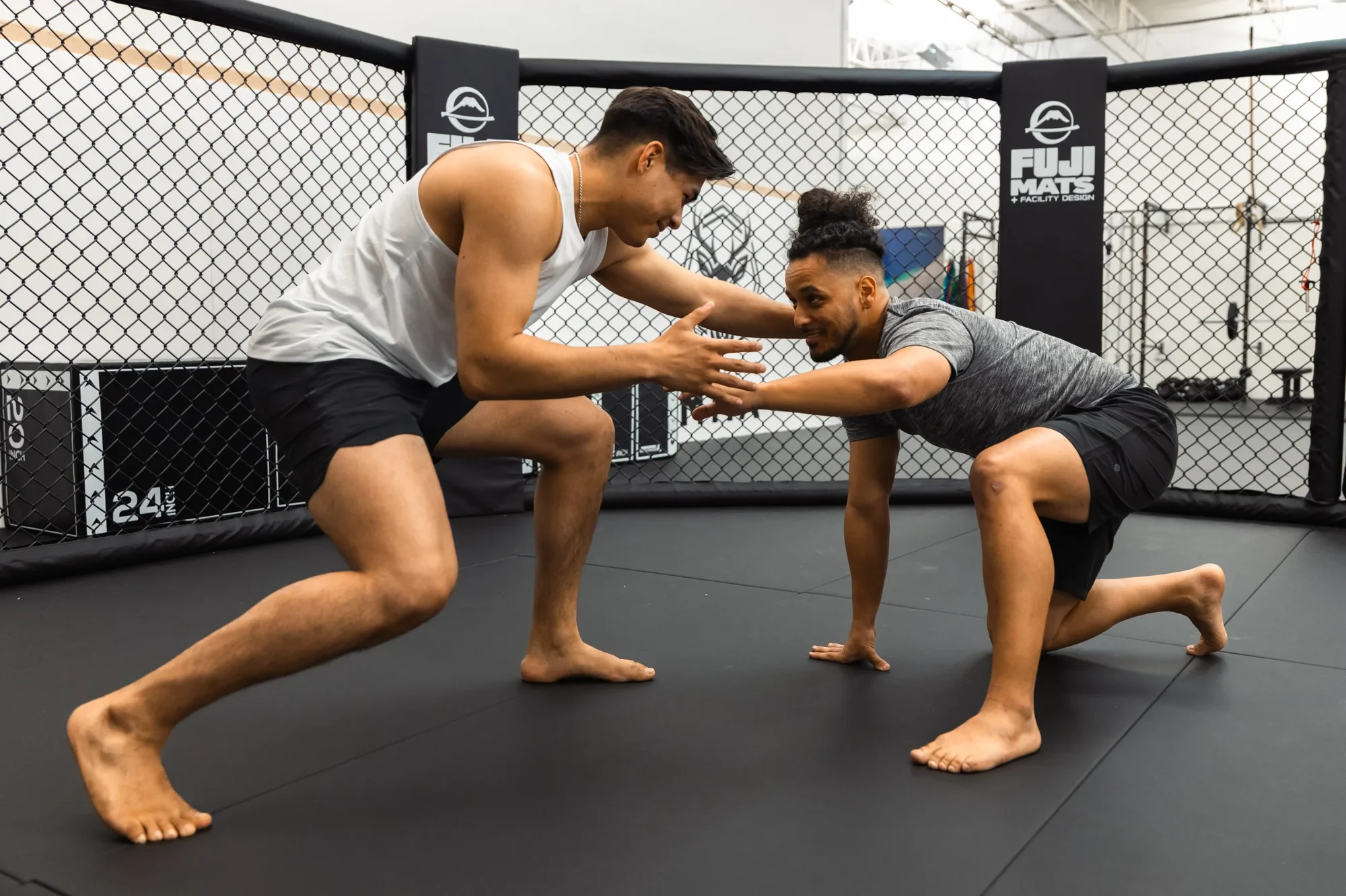 Two athletes hand-fighting inside the cage at Buckhead MMA.