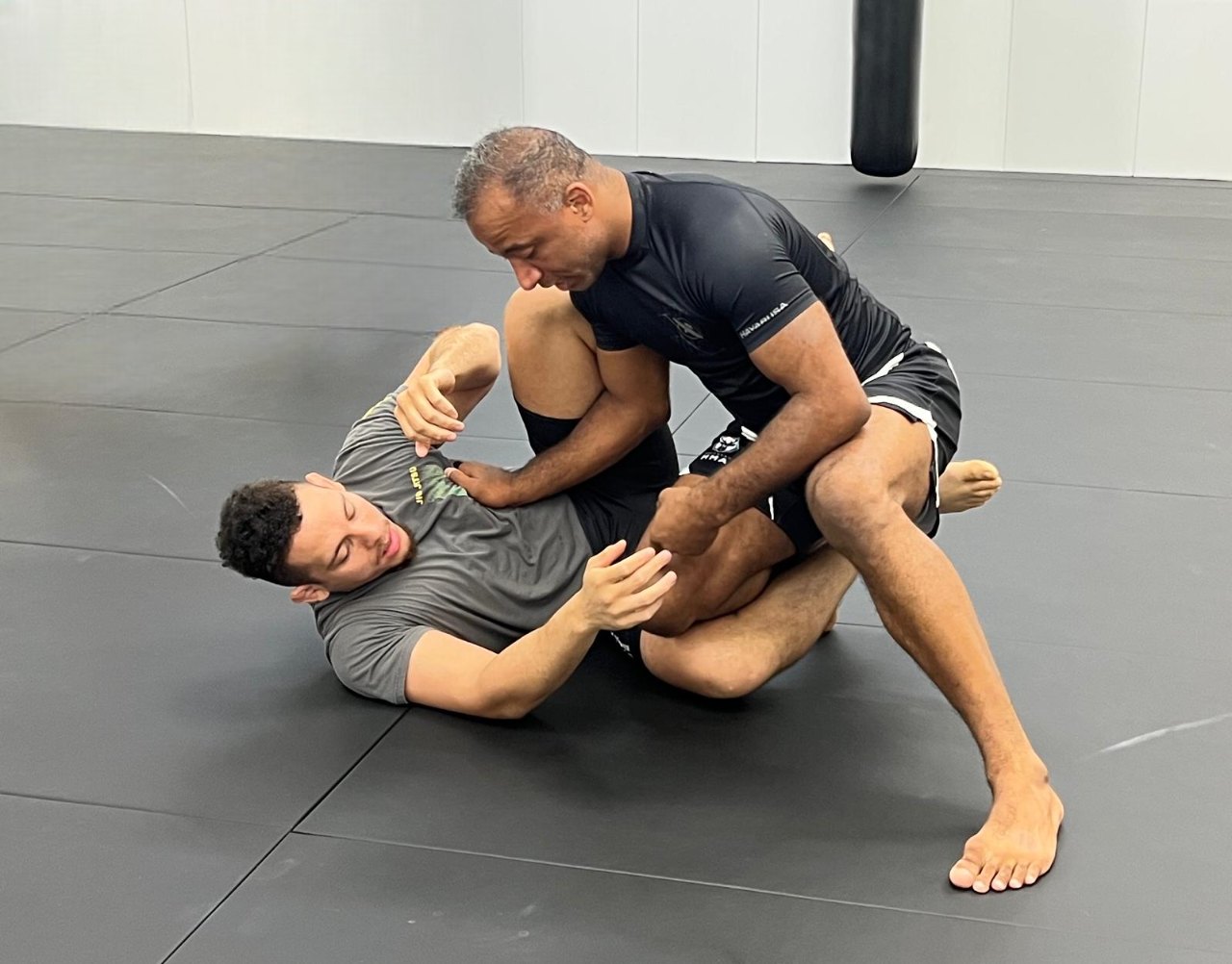 Brazilian jiu-jitsu on the mats, both athletes fully in frame.